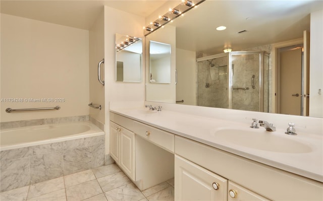 bathroom with a sink, a relaxing tiled tub, a stall shower, and double vanity