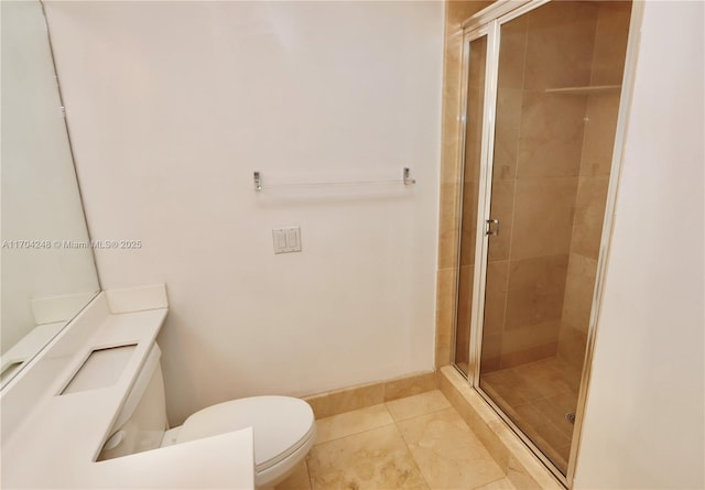 bathroom with a stall shower, toilet, and baseboards