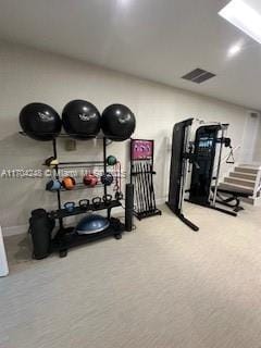 workout room featuring visible vents, a skylight, and carpet flooring