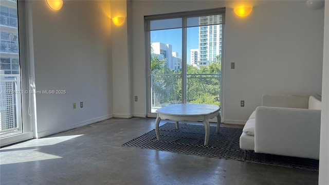 interior space featuring a city view, baseboards, and finished concrete floors