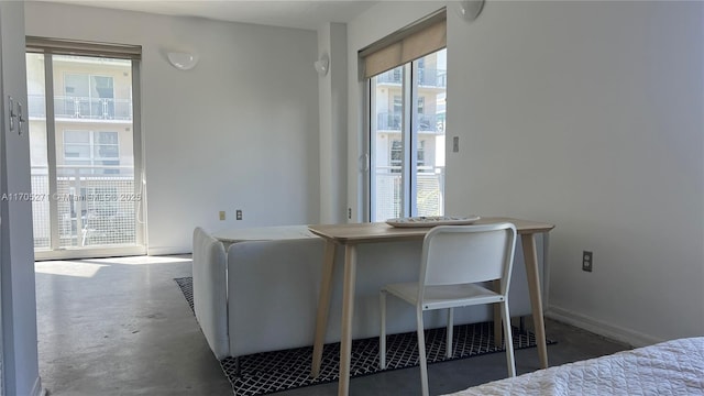 interior space with access to outside, baseboards, and concrete flooring