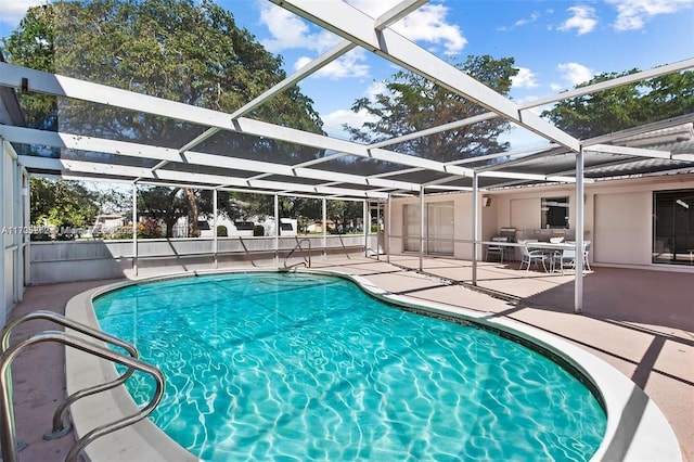 view of pool with glass enclosure and a patio area