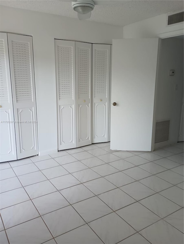 9141 SW Sunrise Lakes Blvd Unit 219, Sunrise, FL 33322 - unfurnished bedroom with light tile patterned floors and multiple closets