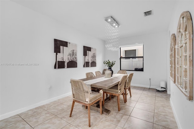 tiled dining space featuring an inviting chandelier