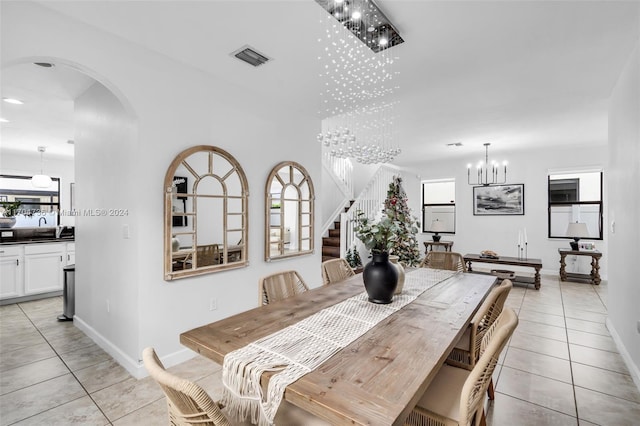 dining space featuring light tile patterned flooring and a chandelier