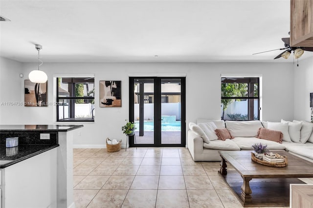 living room with plenty of natural light, ceiling fan, light tile patterned floors, and french doors