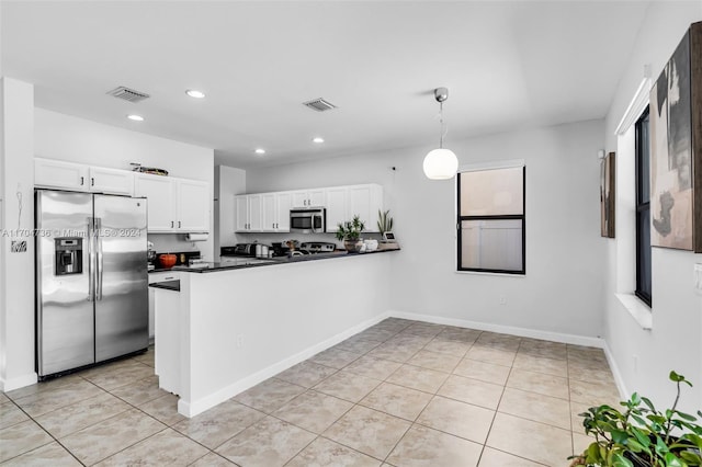 kitchen featuring hanging light fixtures, light tile patterned floors, kitchen peninsula, white cabinets, and appliances with stainless steel finishes