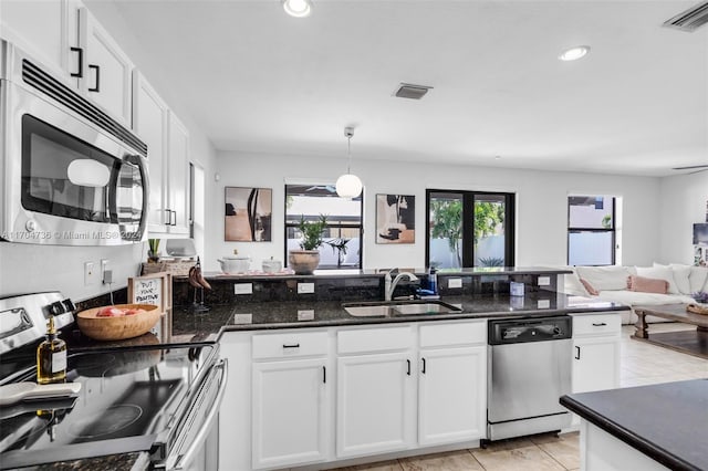 kitchen with stainless steel appliances, white cabinetry, and sink