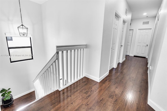 corridor featuring a chandelier and dark hardwood / wood-style floors