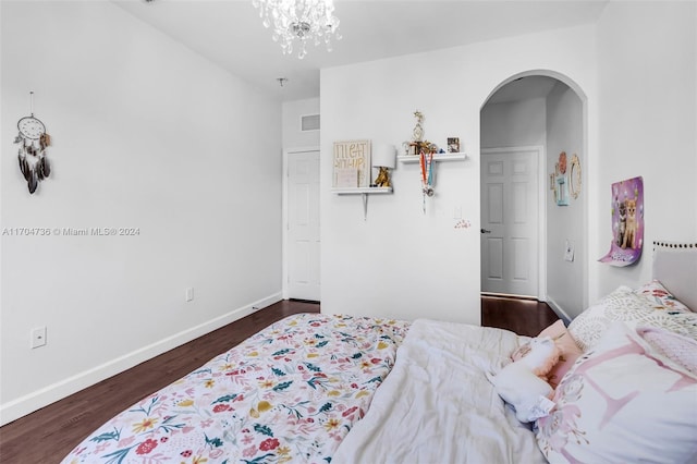 bedroom featuring dark hardwood / wood-style floors and a notable chandelier