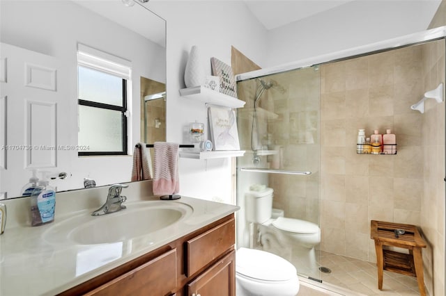 bathroom featuring vanity, an enclosed shower, and toilet