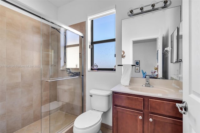 bathroom featuring a healthy amount of sunlight, toilet, and a shower with door