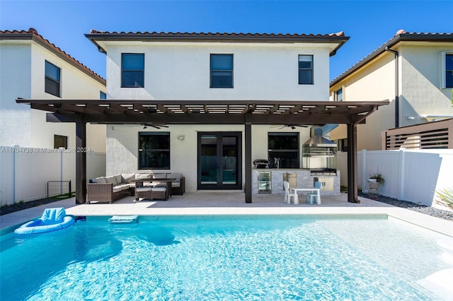 rear view of property featuring a pergola, outdoor lounge area, ceiling fan, exterior kitchen, and a patio