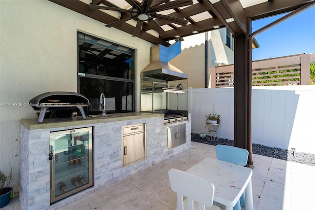 view of patio / terrace featuring wine cooler, ceiling fan, sink, and an outdoor kitchen