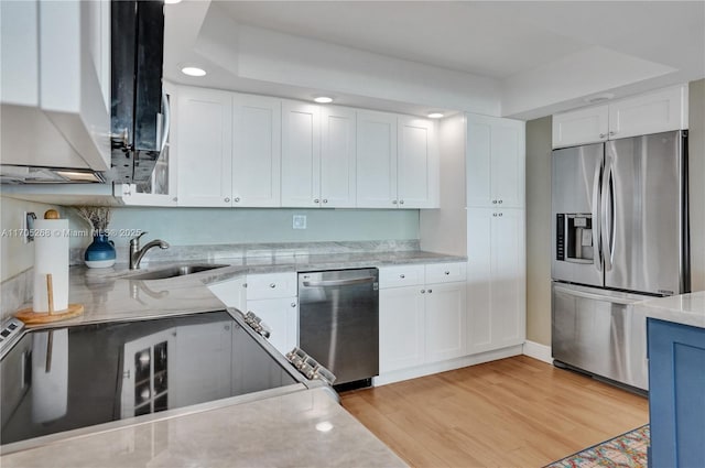 kitchen featuring white cabinetry, sink, stainless steel appliances, and light hardwood / wood-style flooring