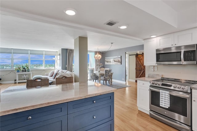 kitchen with white cabinetry, appliances with stainless steel finishes, blue cabinets, and a barn door