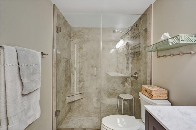 bathroom with toilet, vanity, and a shower with shower door