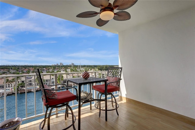 balcony featuring a water view and ceiling fan