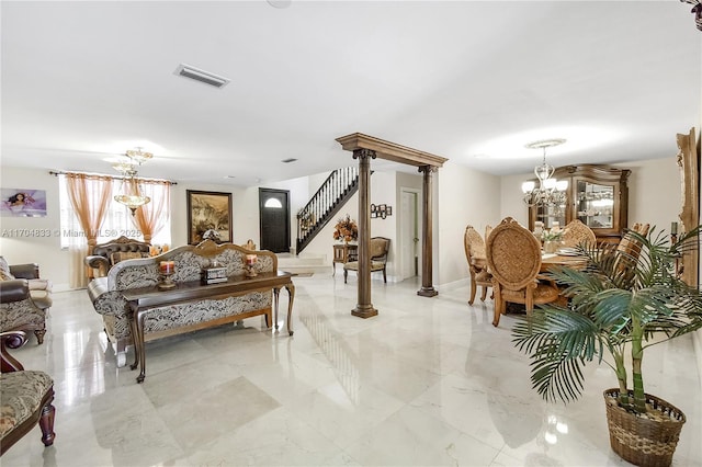 living room featuring a chandelier and ornate columns