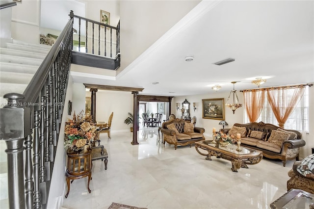 living room featuring crown molding, plenty of natural light, and a towering ceiling