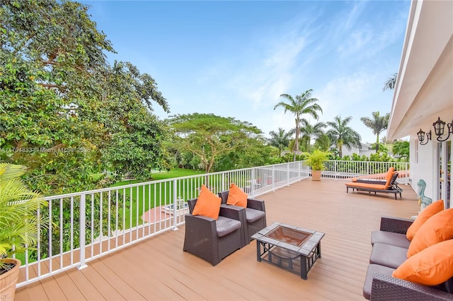 deck featuring an outdoor living space with a fire pit