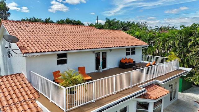 rear view of property featuring french doors and a balcony