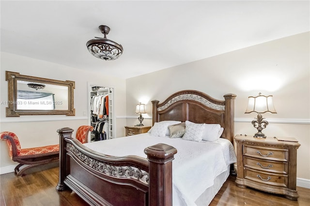 bedroom with dark hardwood / wood-style floors, a closet, and a spacious closet