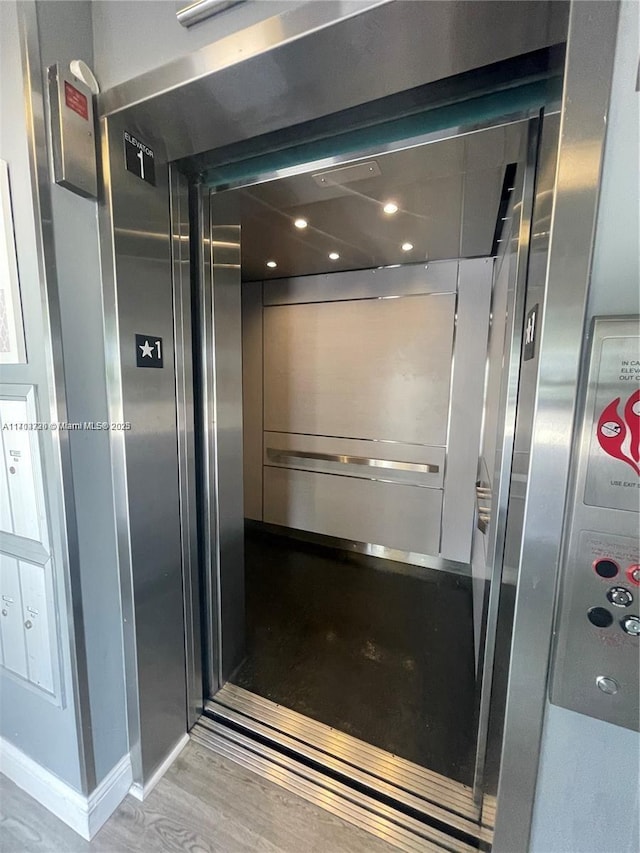 interior details featuring wood-type flooring and elevator