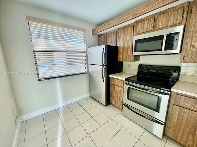 kitchen with appliances with stainless steel finishes and light tile patterned floors