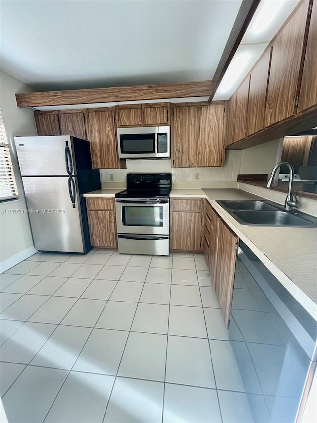 kitchen featuring sink, light tile patterned floors, and appliances with stainless steel finishes