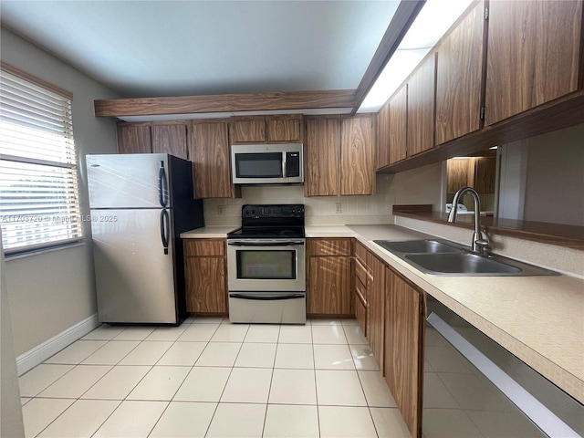 kitchen with stainless steel appliances, light tile patterned flooring, and sink