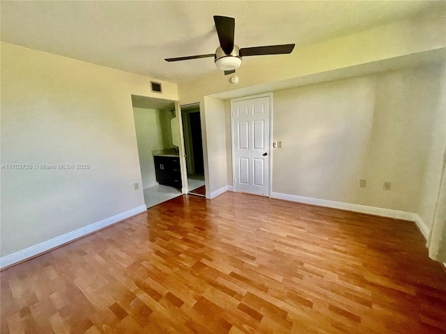 unfurnished bedroom featuring hardwood / wood-style flooring, ceiling fan, and a closet