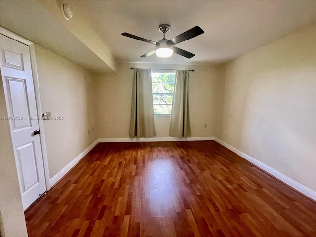 spare room featuring ceiling fan and dark hardwood / wood-style flooring