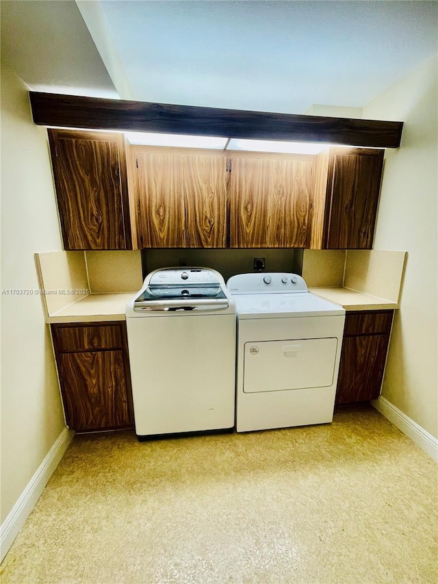 laundry room featuring cabinets and washer and clothes dryer