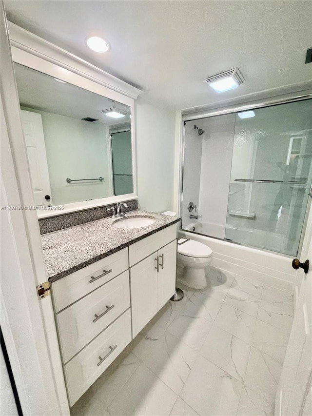 full bathroom with bath / shower combo with glass door, vanity, and toilet