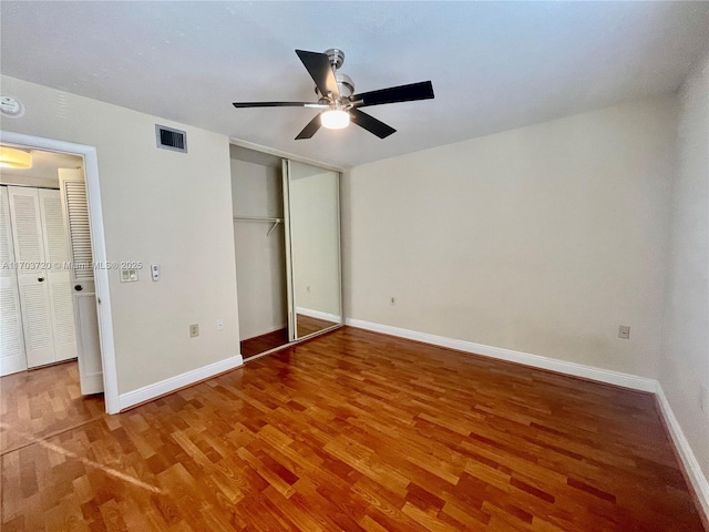 unfurnished bedroom with ceiling fan, wood-type flooring, and a closet