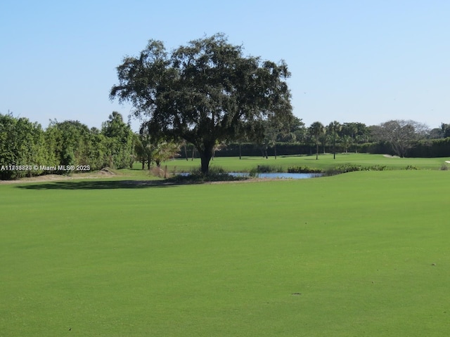 surrounding community featuring a water view and a lawn