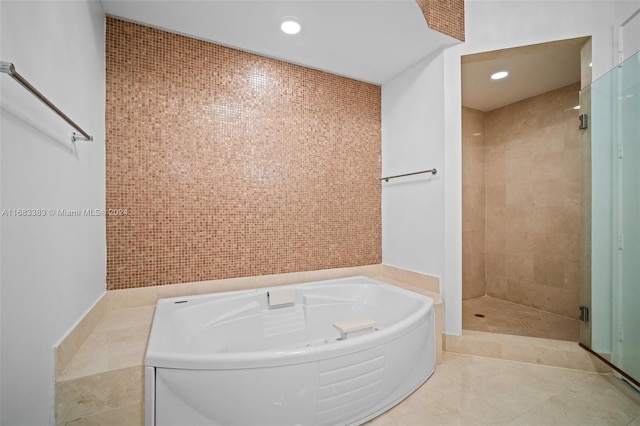 bathroom with separate shower and tub, tile patterned flooring, and tile walls