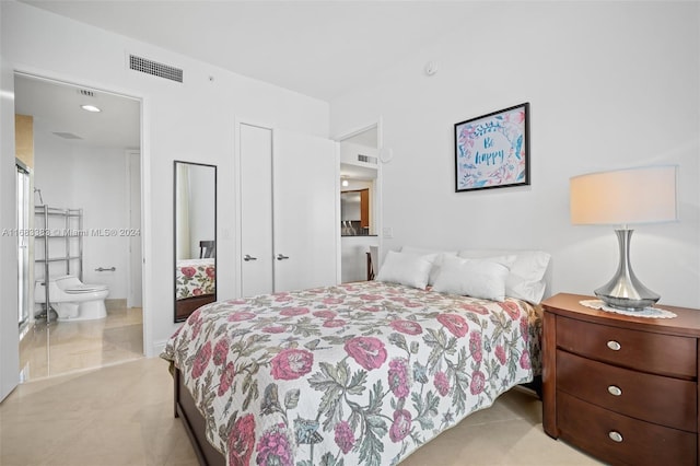 bedroom featuring light carpet and ensuite bathroom