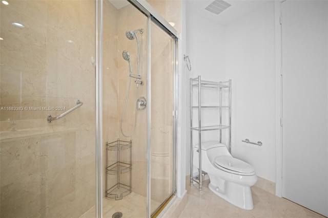 bathroom with toilet, tile patterned floors, and a shower with door