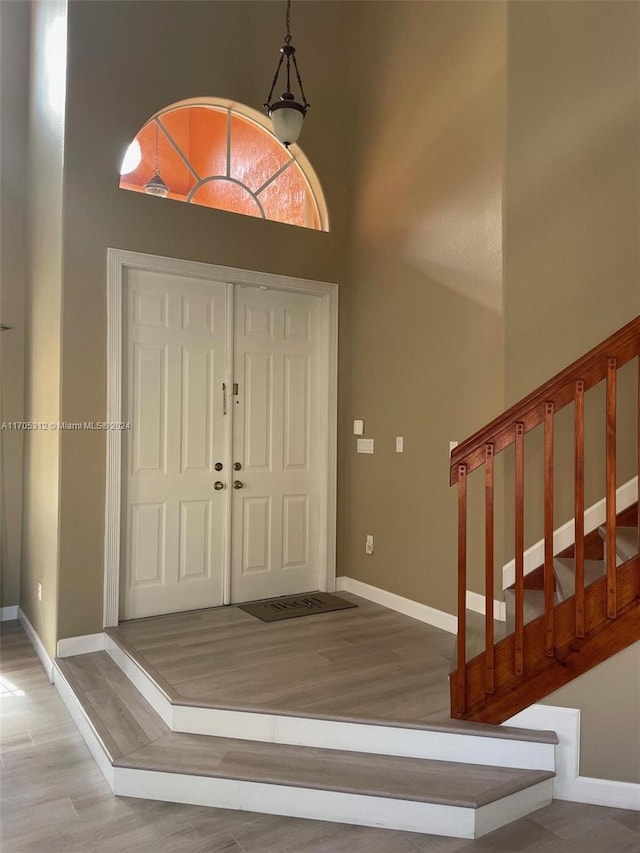 foyer entrance featuring a high ceiling and light hardwood / wood-style flooring