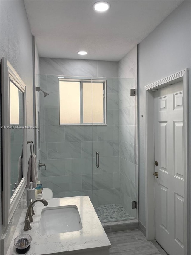 bathroom featuring vanity and a shower with door