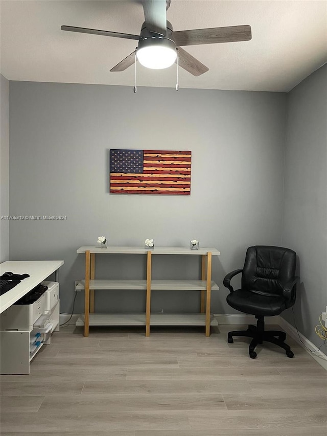 home office with light hardwood / wood-style floors and ceiling fan