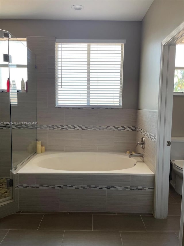 bathroom featuring tile patterned floors, toilet, and independent shower and bath