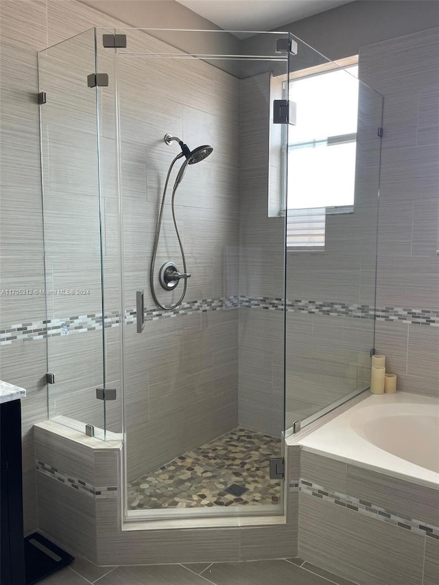 bathroom with plus walk in shower, vanity, and tile patterned flooring