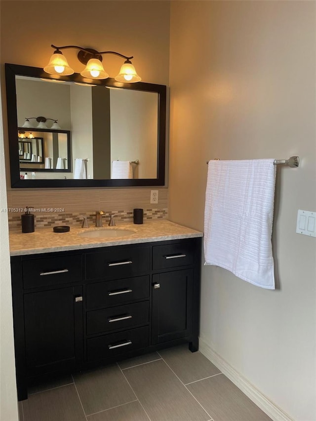 bathroom with tile patterned flooring, vanity, and backsplash