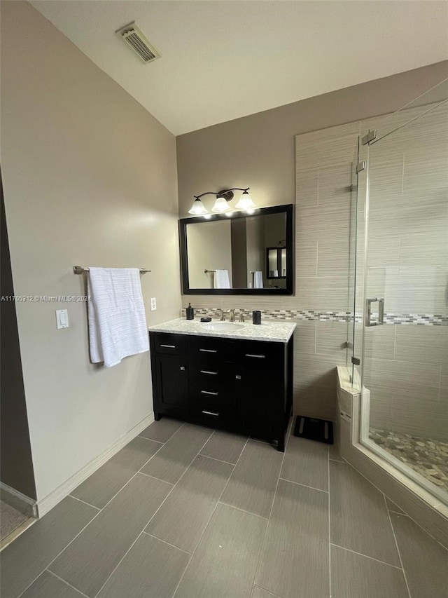 bathroom with tile patterned floors, vanity, and an enclosed shower