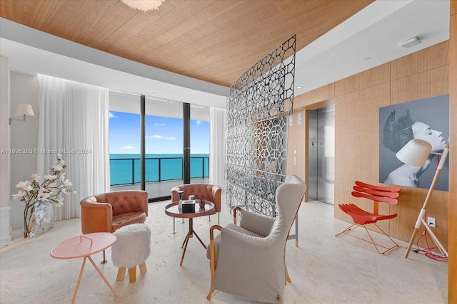 living area with a water view, wood ceiling, and elevator