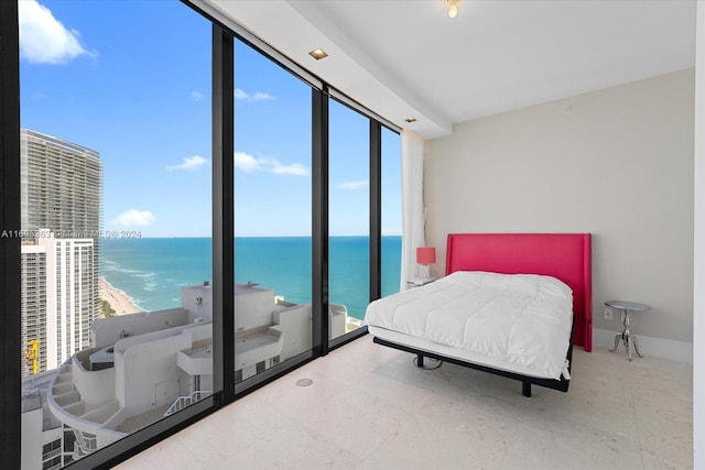 bedroom with a water view and a view of the beach