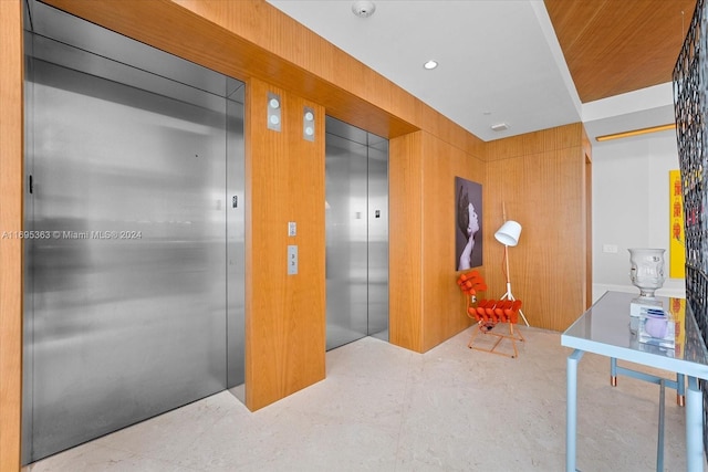 interior space with elevator and wooden walls